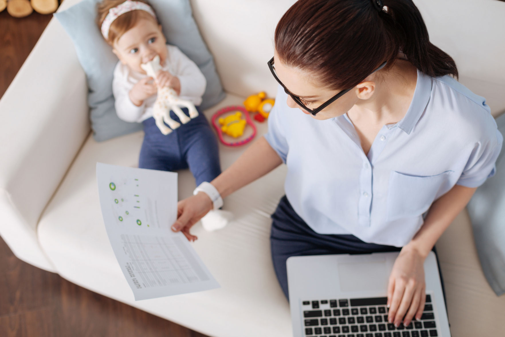Serious business lady sitting on a couch with her child
